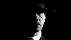 Tajemnicza twarz mężczyzny znajdująca się w półcieniu.